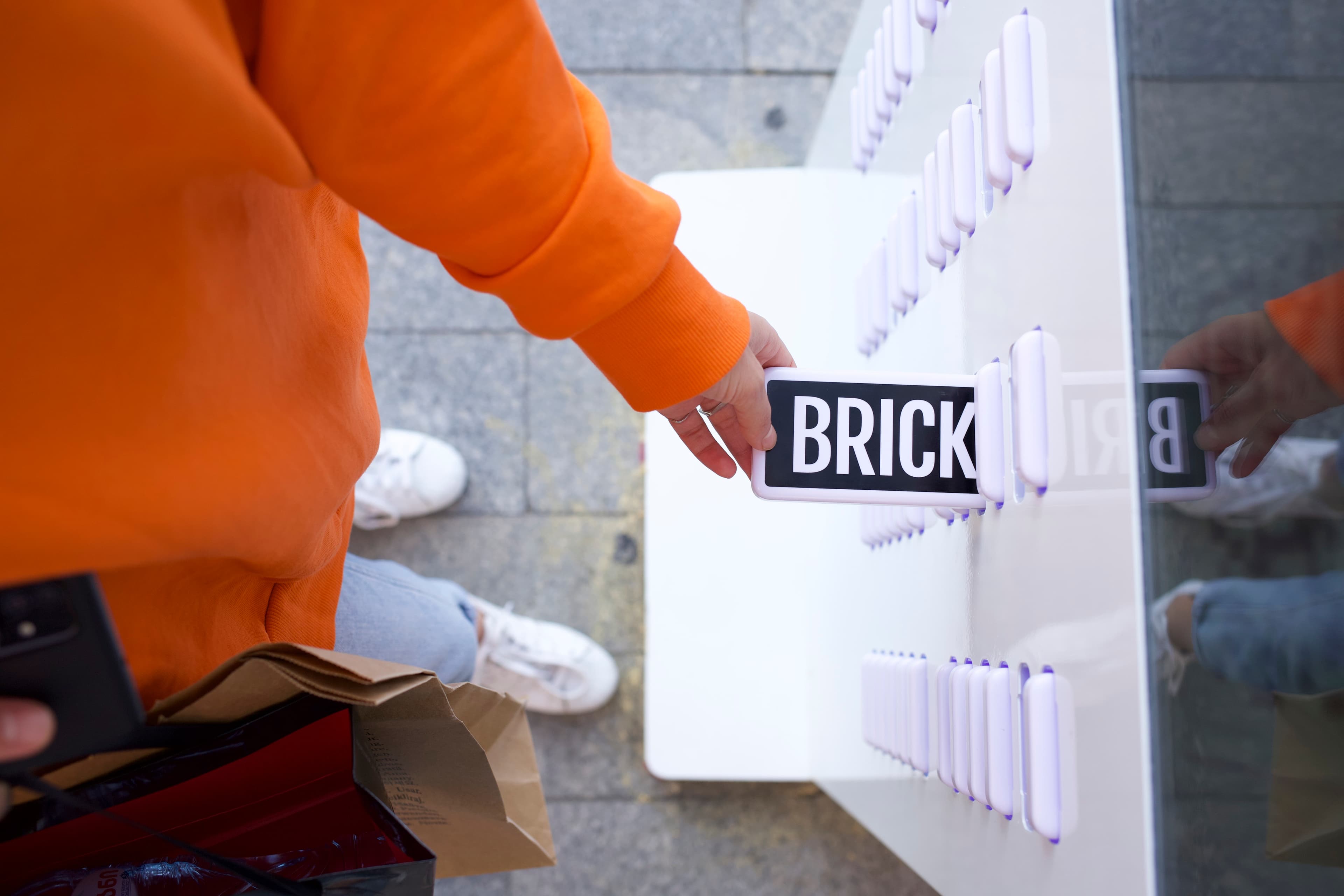 Een hand die een Brick powerbank uit een station haalt